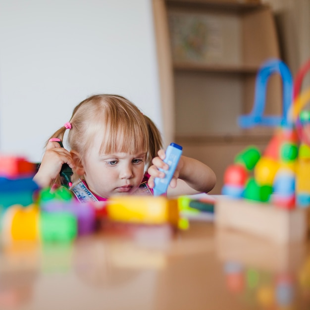 Kleine niedliche Mädchen spielen mit Marker Stifte