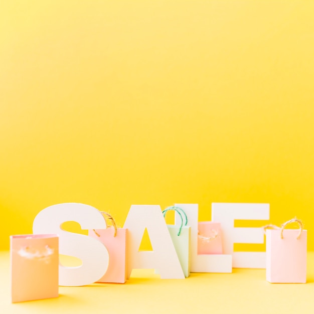 Kleine rosa Einkaufstasche vor Briefverkauf auf gelbem Hintergrund