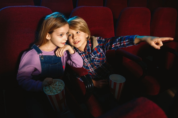 Kleine schwester und bruder schauen sich einen film im kino an