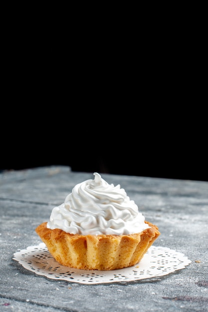 kleiner cremiger Kuchen gebacken köstlich isoliert auf grauem hellem Schreibtisch, Kuchenkeks süße Sahne