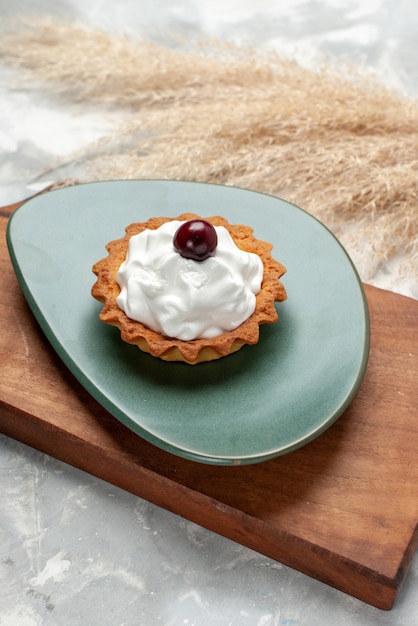 Kostenloses Foto kleiner cremiger kuchen mit früchten auf licht, kuchencreme süß backen