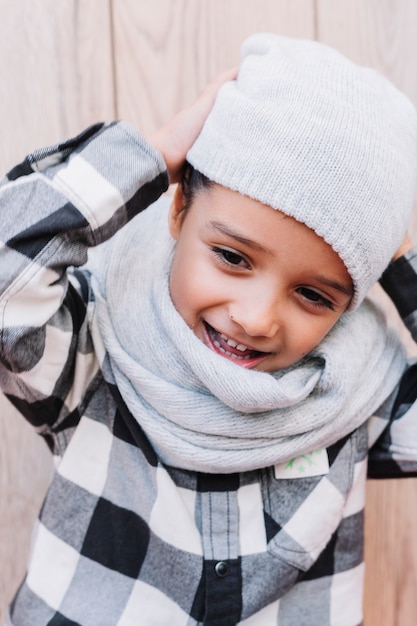 Kostenloses Foto kleiner junge, der auf wintermütze sich setzt