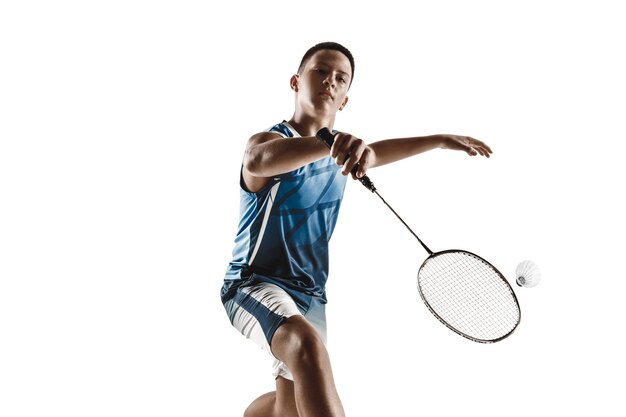 Kleiner Junge, der Badminton lokalisiert auf weißem Hintergrund spielt.