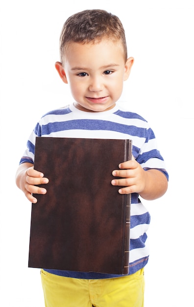 Kleiner Junge, der ein Buch mit sieben Siegeln halten