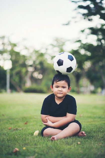 Kleiner Junge, der Fußballfußball spielt