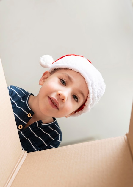 Kleiner Junge, der in einer Geschenkbox schaut