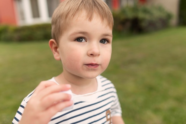 Kleiner Junge, der mit Blasengebläse spielt