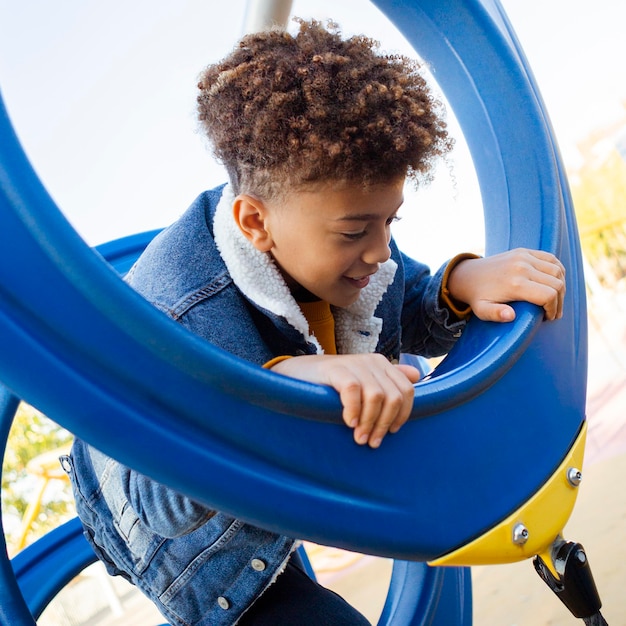 Kostenloses Foto kleiner junge, der spaß am spielplatz hat