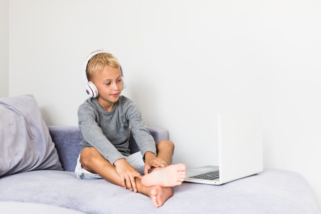 Kleiner Junge, der Spaß mit Laptop hat