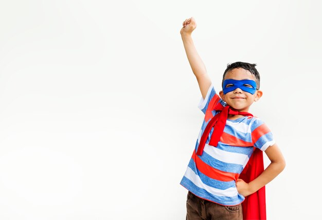 Kleiner Junge, der Superhelden am Spielplatz spielt