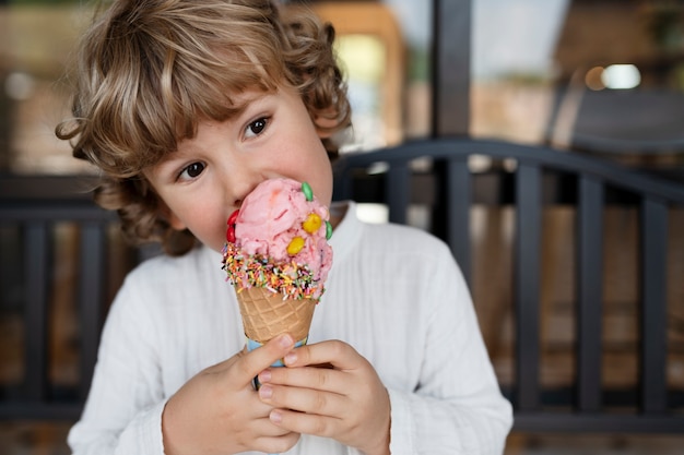 Kleiner Junge der Vorderansicht, der Eiscreme isst