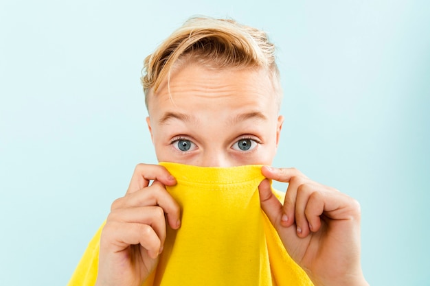 Kleiner Junge der Vorderansicht, der mit T-Shirt spielt