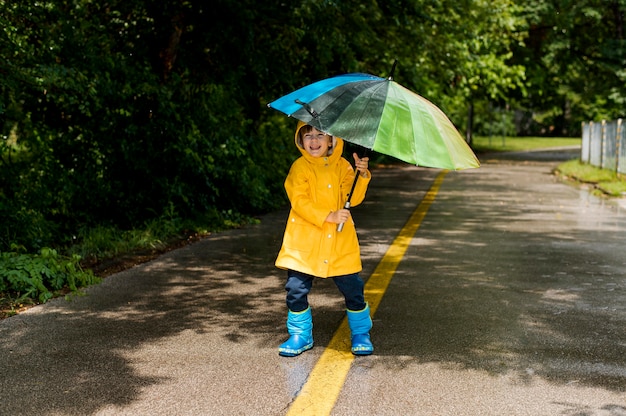 Kleiner Junge hält einen Regenschirm