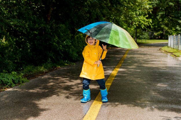 Kleiner Junge hält einen Regenschirm