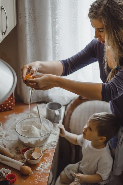 kleiner Junge in der Küche hilft Mama beim Kochen. Das Kind ist am Kochen beteiligt.