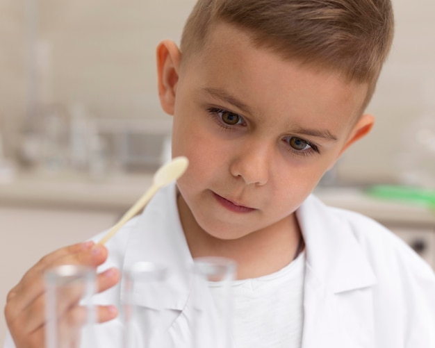 Kleiner Junge macht ein wissenschaftliches Experiment in der Schule