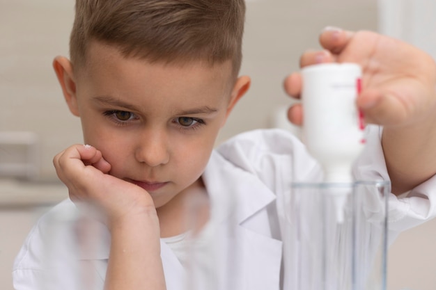 Kleiner junge macht ein wissenschaftliches experiment in der schule