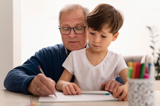 Kleiner Junge macht Hausaufgaben mit seiner Großmutter
