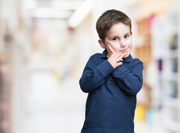 Kleiner Junge mit den Händen auf seinem Gesicht