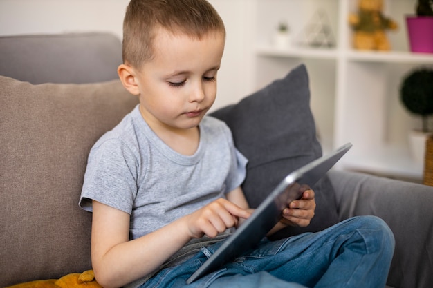 Kleiner Junge schaut auf sein Tablet