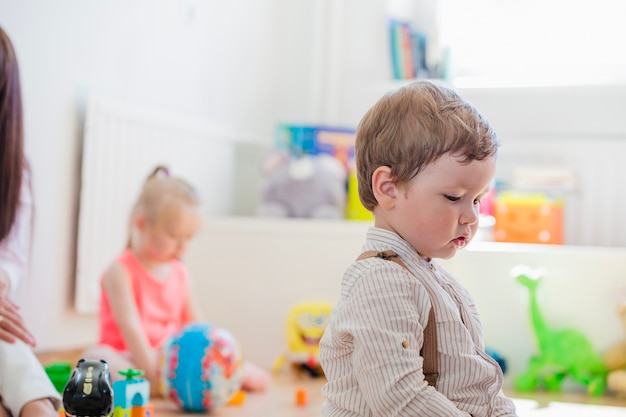 Kleiner Junge sitzt im Spielzimmer