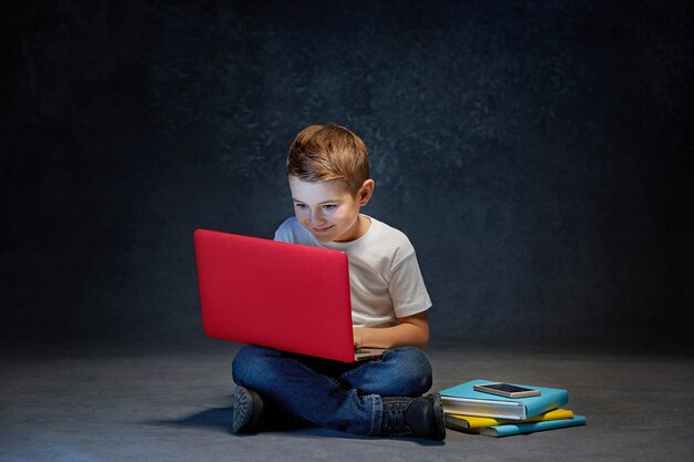 Kleiner Junge sitzt mit Laptop