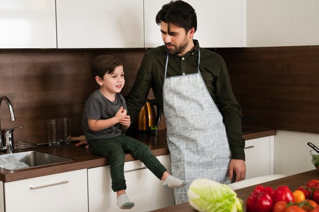 Kleiner Junge und Vater des hohen Winkels in der Küche