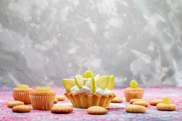kleiner köstlicher Kuchen mit geschnittenen Fruchtkeksen auf farbigem Schreibtisch, Kuchen süßes Farbfoto