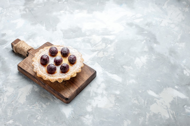 Kleiner kuchen mit früchten auf hellem schreibtisch, kuchenkeks süß backen