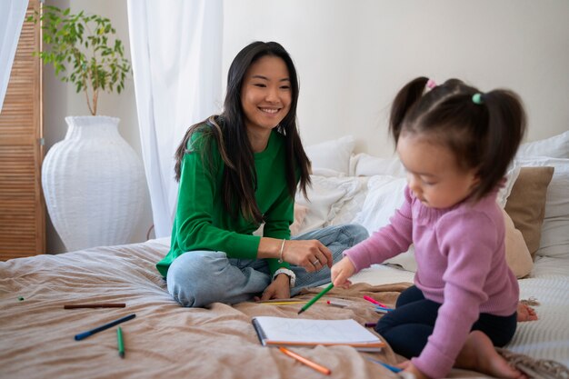 Kleines asiatisches Mädchen, das Zeit zu Hause mit ihrer Mutter verbringt