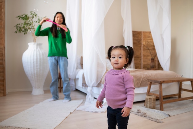 Kleines asiatisches Mädchen, das Zeit zu Hause mit ihrer Mutter verbringt