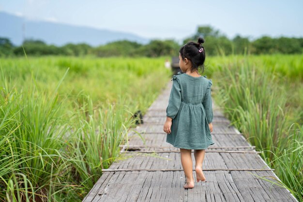 Kleines asiatisches weibliches Kind, das in einen Park geht