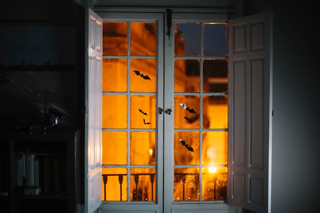 Kleines Halloween-Papier schlägt auf Fenster im Raum