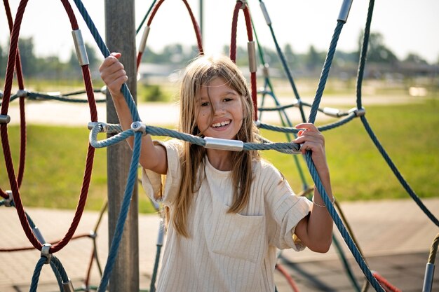 Kleines Kind, das sich auf dem Spielplatz im Freien amüsiert