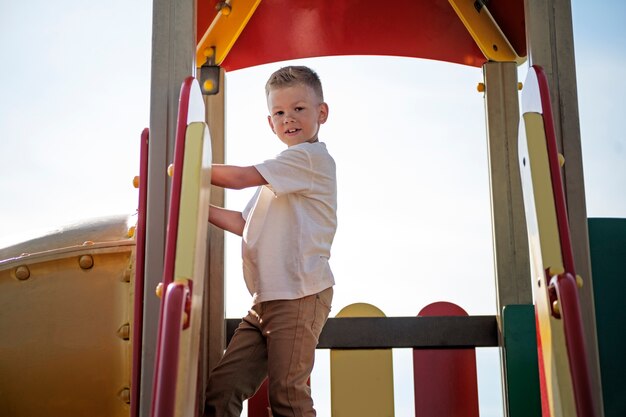 Kleines Kind, das sich auf dem Spielplatz im Freien amüsiert