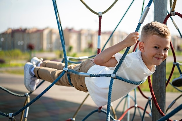 Kleines Kind, das sich auf dem Spielplatz im Freien amüsiert