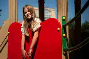 Kostenloses Foto kleines kind, das sich auf dem spielplatz im freien amüsiert