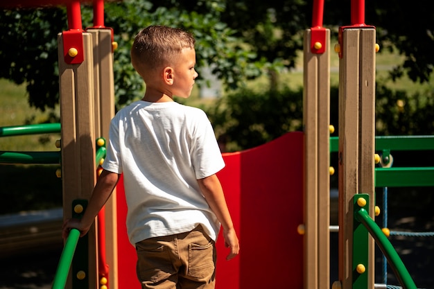 Kostenloses Foto kleines kind, das sich auf dem spielplatz im freien amüsiert