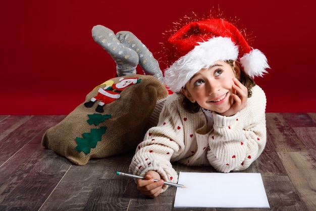 Kleines Mädchen auf dem Boden liegend mit einem Bleistift träumen wach und ein Papier