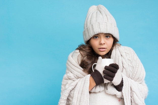 Kleines Mädchen auf Winter heißen Tee Kopieraum trinkend