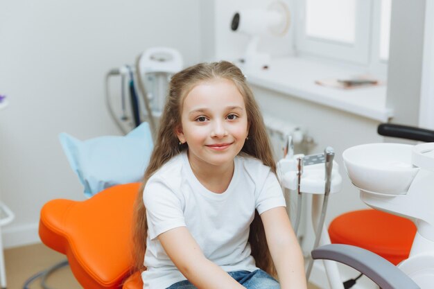 Kleines mädchen beim zahnarzt porträt eines lächelnden mädchens im zahnarztstuhl