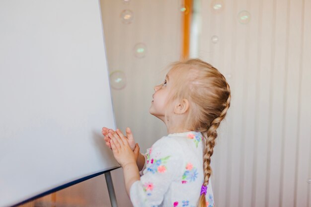 Kleines Mädchen Blick auf Seifenblasen