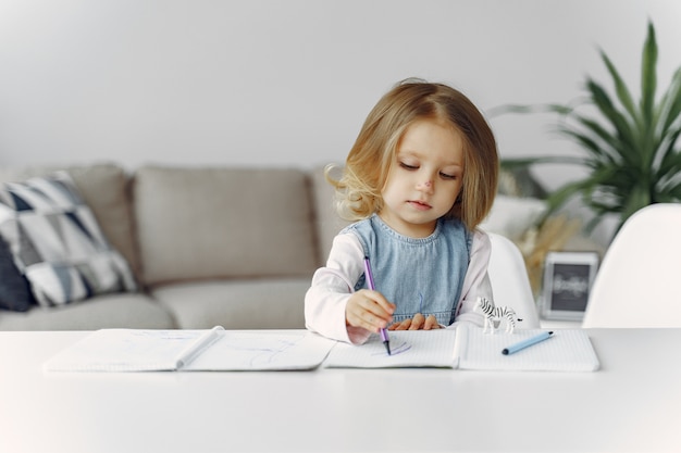 Kleines mädchen, das auf einem tisch mit büchern sitzt