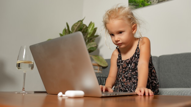Kleines Mädchen, das auf Laptop spielt. Hochwertiges Foto