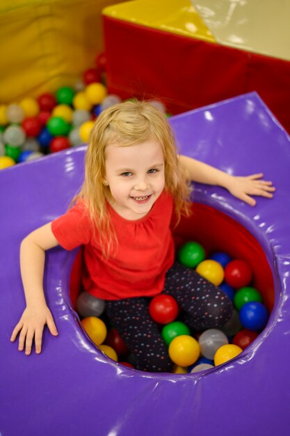 Kleines Mädchen, das Ballgrube genießt