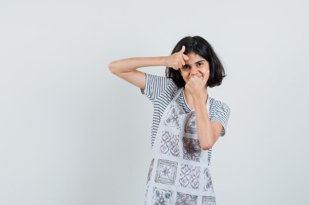 Kleines Mädchen, das doppelte Daumen oben im T-Shirt zeigt