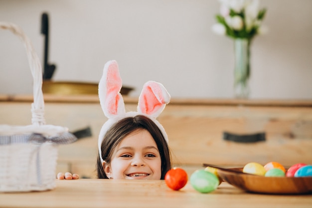 Kleines Mädchen, das Eier für Ostern malt