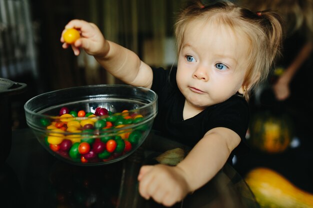 Kleines Mädchen, das eine gelbe Bonbons halten