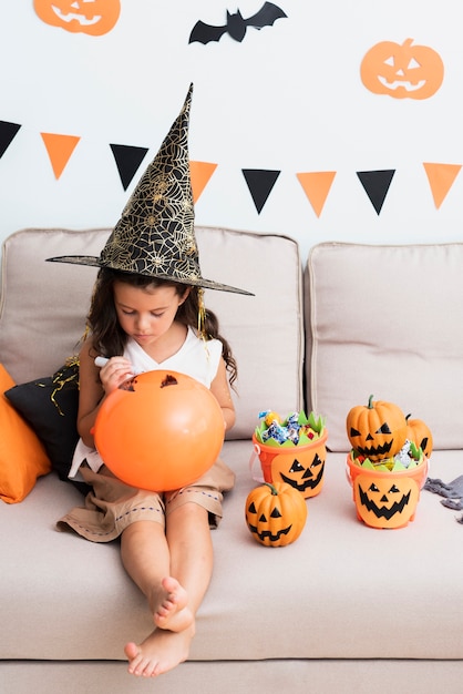 Kostenloses Foto kleines mädchen, das einen halloween-ballon zeichnet