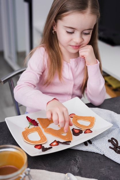 Kleines Mädchen, das Frühstück am Vatertag zubereitet